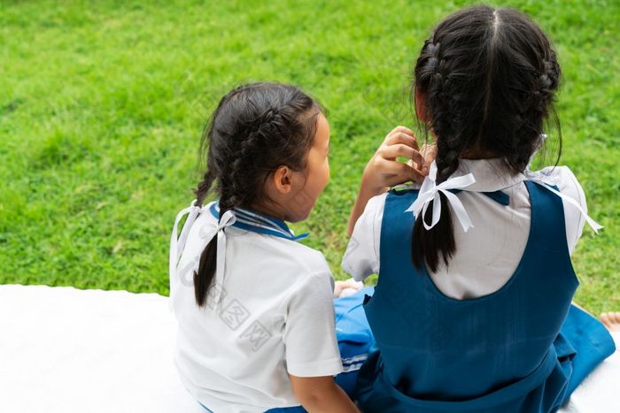 两个小亚洲女孩姐妹拥抱快乐帖子学校统一的回来学校概念