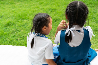 两个小亚洲女孩姐妹拥抱快乐帖子学校统一的回来学校概念