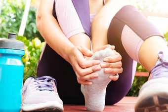 脚踝扭伤了年轻的女人痛苦从脚踝受伤而锻炼和运行医疗保健和体育运动概念