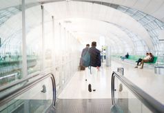 旅行者与旅行袋行李走的机场终端人行道为空气旅行模糊运动