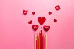 情人节一天概念红色的心和颜色铅笔粉红色的背景