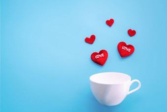 情人节rsquo一天概念红色的心与白色咖啡杯蓝色的背景