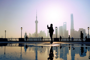旅行者取照片早....活动的履行。黄埔河畔上海城市视图背景