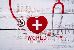 世界红色的交叉一天红色的心与听诊器木表格背景