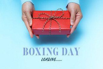 拳击一天加载年轻的女人手与礼物盒子提供接收机