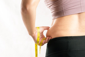 脂肪女人脂肪肚子<strong>胖</strong>乎乎的肥<strong>胖</strong>女人手捏她的过度肚子脂肪腰与测量磁带女人饮食生活方式概念后视图