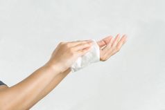 女人清洁她的手与白色软组织纸孤立的白色背景