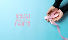 粉红色的徽章丝带女人手支持乳房癌症导致乳房癌症意识概念