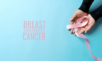 粉红色的徽章丝带女人手支持<strong>乳房</strong>癌症导致<strong>乳房</strong>癌症意识概念