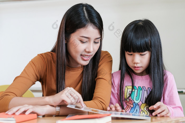 年轻的亚洲女人老师教学女孩幼儿园教室学前教育教育概念