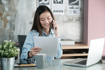 年轻的亚洲女商人工作和会说话的电话办公室表格业务休闲生活方式