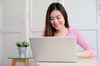 年轻的亚洲女人使用移动PC电脑和微笑与幸福人和技术生活方式教育业务概念