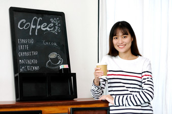 年轻的亚洲女人持有取走了纸咖啡杯而站附近<strong>咖啡菜单</strong>董事会咖啡馆背景食物和喝业务概念人生活方式