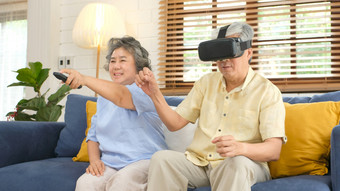 <strong>高级</strong>亚洲夫妇玩虚拟现实耳机和使用数字平板电脑首页生活房间与幸福情<strong>感</strong>退休生活方式和技术