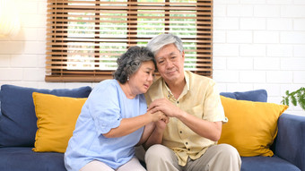 高级亚洲夫妇令人欣慰的每一个其他从抑郁情感而坐着沙发首页生活房间老退休生活方式