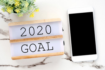 目标木盒子和聪明的电话与空白屏幕白色大理石背景新一年目的成功业务背景