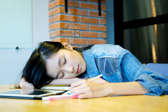 年轻的亚洲女人睡觉疲惫从工作与论文她的办公室桌子上亚洲学生女孩取La2休息后阅读书教育工作晚些时候工作从首页概念