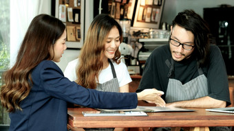 年轻的亚洲业务女人讨论关于<strong>金融</strong>规划与小业务老板咖啡馆咖啡商店业务会议企业伙伴关系亚洲<strong>财经</strong>贷款为开始新业务