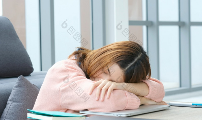 累了亚洲女人睡觉首页办公室桌子上工作从首页困了亚洲女孩大学学生取打破从在线研究打盹过度劳累女生活房间