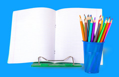 学校笔记本和彩色的铅笔蓝色的玻璃白色背景