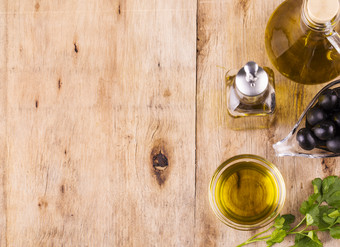橄榄石油瓶维珍橄榄石油橄榄和健康的橄榄石油瓶和杯与欧芹老木表格饮食节食概念健康的吃