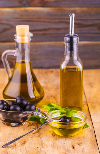 橄榄石油瓶维珍橄榄石油橄榄和健康的橄榄石油瓶和杯与欧芹老木表格