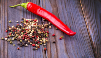 红色的热辣椒胡椒和轮多色的辣椒木背景红色的热辣椒胡椒和轮多色的辣椒