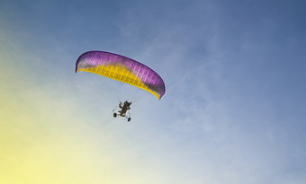 的滑翔伞与电动机苍蝇的蓝色的天空滑翔伞与电动机苍蝇的蓝色的天空