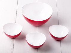 空红色的沙拉碗和三个杯白色木表格空红色的沙拉碗和杯白色木表格
