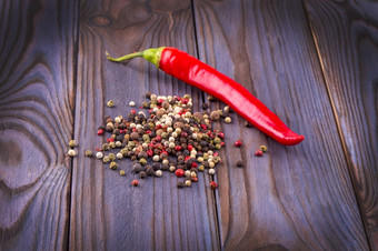 红色的热辣椒胡椒和轮多色的辣椒木背景红色的热辣椒胡椒和轮多色的辣椒