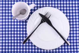 empy杯子与勺子板与刀和叉的桌布笼子里视图从以上与复制空间empy杯子与勺子板与刀和叉