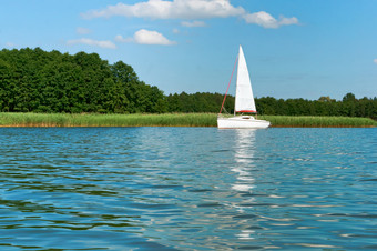 一个游艇的湖夏天孤独的白色游艇一个游艇与白色帆