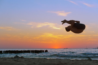 杂技演员日落的海海岸翻<strong>筋</strong>斗的海滩杂技的海杂技的海体操运动员日落的海海岸翻<strong>筋</strong>斗的海滩