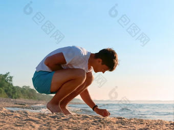 的男孩收集石头的海收集石头的海海岸的年轻的男人。休息的海海岸收集石头的海海岸的男孩收集石头的海的年轻的男人。休息的海海岸
