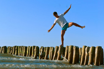 年轻的男人。站的防浪堤木防浪堤防浪堤的海为保护从的<strong>风暴</strong>木防浪堤年轻的男人。站的防浪堤防浪堤的海为保护从的<strong>风暴</strong>