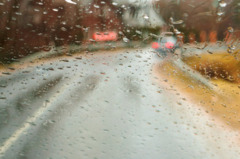 雨滴的车视图通过湿玻璃多雨的天气湿路视图通过湿玻璃多雨的天气湿路雨滴的车