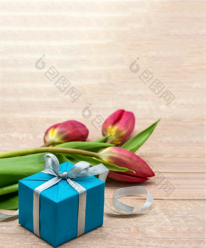 礼物和郁金香木背景春天花和礼物盒子红色的郁金香和蓝色的包装