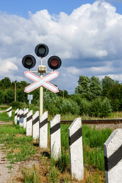 红色的交通光的铁路穿越注意司机警告标志之前的铁路穿越垂直红色的交通光的铁路穿越警告标志之前的铁路穿越垂直注意司机