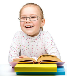 的快乐的小女孩阅读书而穿眼镜孤立的在