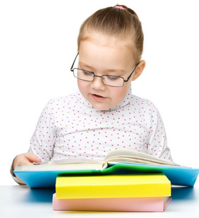 的小女孩阅读书穿眼镜孤立的在