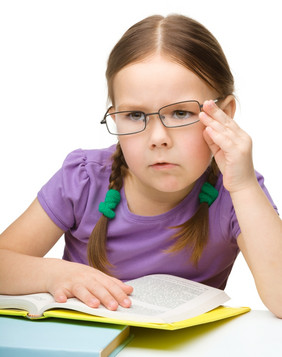 的小女孩阅读书穿眼镜孤立的在