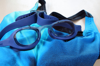 蓝色的游泳护目镜和蓝色的泳衣为洗澡游泳池
