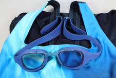 蓝色的游泳护目镜在蓝色的泳衣
