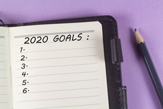 笔记本与目标和铅笔紫色的背景