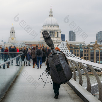 回来unidentifitable音乐的街表演者携带上行下来大提琴的千禧年桥俯瞰保罗rsquo大教堂伦敦英格兰回来unidentifitable音乐的街表演者携带上行下来大提琴的千禧年桥俯瞰保罗rsq