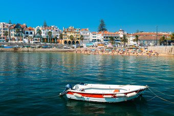 管理葡萄牙8月钓鱼船前景与拥挤的桑迪海滩管理附近里斯本葡萄牙在的夏天这海滩已知的沙滩上贝拉钓鱼船前景与拥挤的桑迪海滩管理附近里斯本葡萄牙在的夏天这海滩已知的沙滩上贝拉