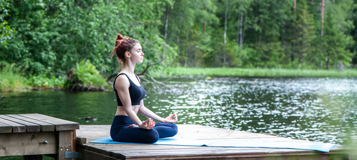 年轻的女孩练习瑜伽的自然的湖女幸福景观背景全景视图