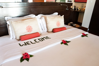 大床上与白色枕头和被单装饰与热带花和登记欢迎主题<strong>酒店</strong>服务<strong>酒店</strong>海滩休息