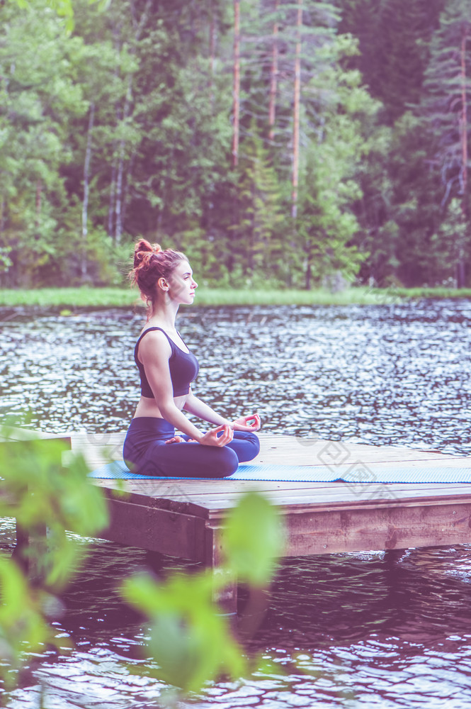 瑜伽冥想年轻的瑜珈女孩的码头美丽的湖的概念绥靖政策健康的生活方式