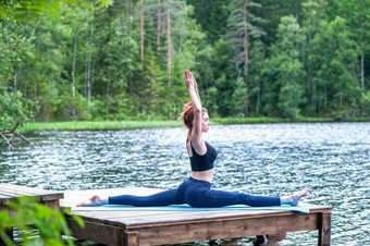 年轻的瑜珈女孩练习瑜伽伸展运动猴子神锻炼分裂哈努马纳萨纳构成的湖的概念绥靖政策健康的生活方式